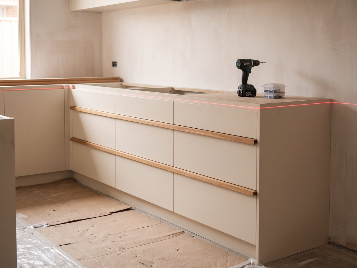 kitchen renovation timeline in New South Wales — SteepWood custom joinery Custom kitchen base cabinets levelled before porcelain benchtop measurement in NSW